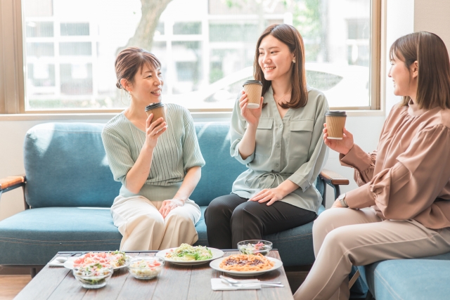 カフェで談笑する女性、コーヒー、サラダ、パスタ